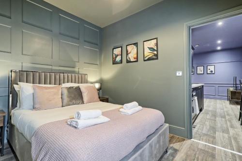 a bedroom with a bed with towels on it at Opulent Abode - Stunning One-Bedroom Flat - Southend Stays in Southend-on-Sea