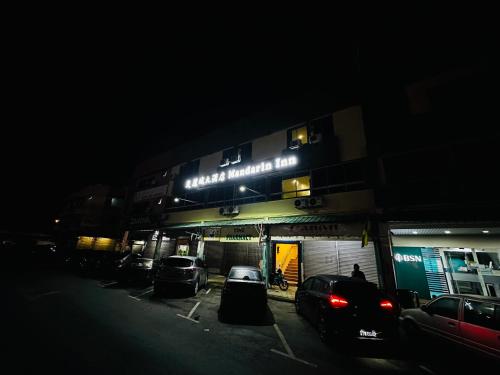 a building with cars parked in a parking lot at night at Mandarin Inn in Mukah