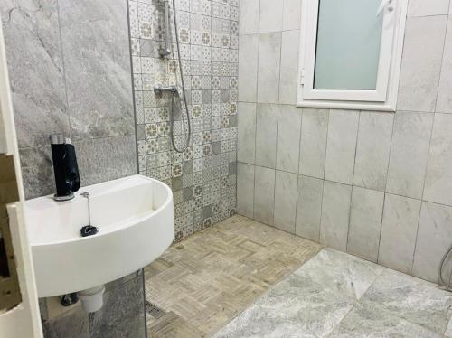 y baño con lavabo y ducha. en Villa Fadhloun 1, en Awlād ‘Umar