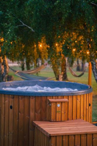 a jacuzzi tub with snow on top of a wooden deck at Domki Podniebo in Jarosławiec