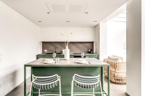 eine Küche mit einer grünen Insel mit 2 Stühlen in der Unterkunft Suite La Panoramica in Massa Lubrense