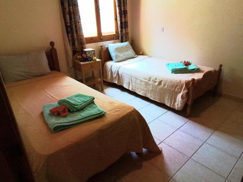 a room with two beds with towels on them at Despina country retreat in Paphos City