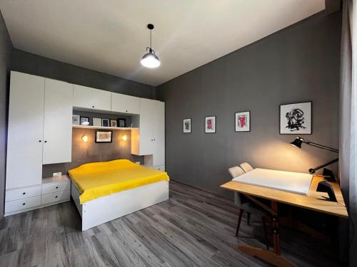 a bedroom with a yellow bed and a desk at Mziuri Guest House in Gonio