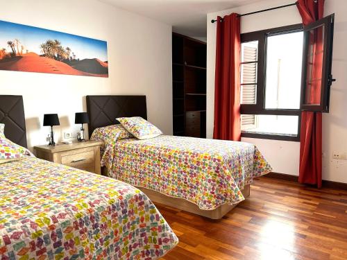 1 Schlafzimmer mit 2 Betten und einem Fenster in der Unterkunft Apartamento Lancelot in Arrecife