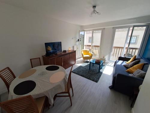 a living room with a table and a couch at Emplacement Top in Alençon