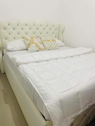 1 cama blanca grande con 2 almohadas en Marc louie estiaga home for rent en Iloilo