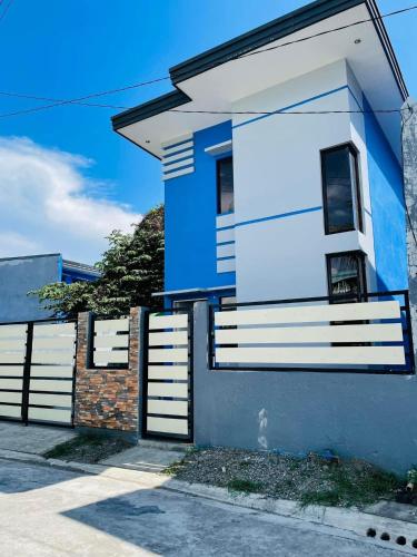 una casa azul y blanca con una valla en Marc louie estiaga home for rent, en Iloilo City