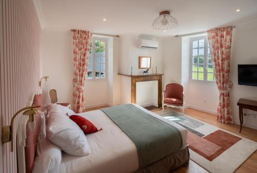 a bedroom with a bed and a desk and windows at Le Relais du Faget 