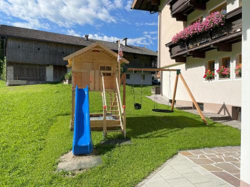a playground with a slide and a play house at Gästehaus Fohringer in Kelchsau