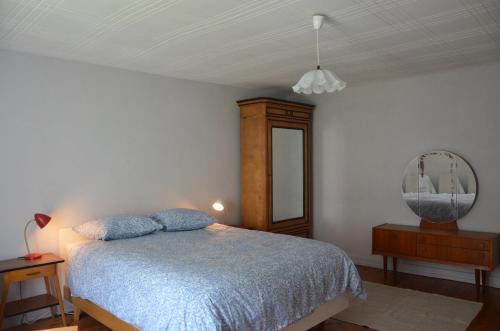 a bedroom with a bed and a dresser and a mirror at les gites du passage: la popote in Passenans