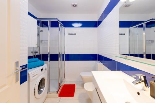bagno blu e bianco con lavatrice di Two bedrooms apartment in Costa Adeje ad Adeje