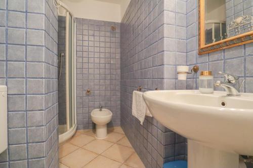 a blue tiled bathroom with a sink and a toilet at "Splendide vue" Front de Mer, Terrasse, Gare train in Roquebrune-Cap-Martin