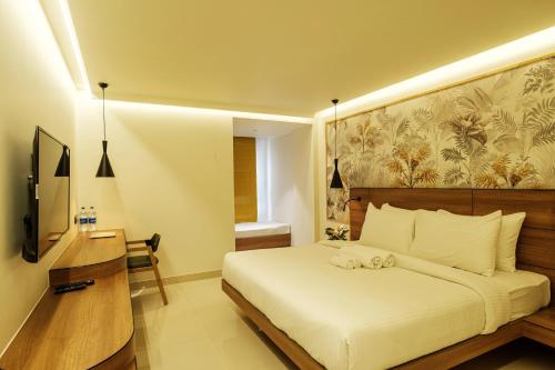 a bedroom with a bed and a desk and a television at Indie Stays Jaipur in Jaipur