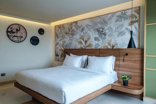 a bedroom with a large bed with a large painting on the wall at Indie Stays Jaipur in Jaipur