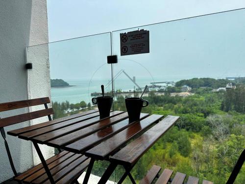 a wooden table on a balcony with a view of the ocean at PD D’Wharf Seaview & Sunset Suite (Up to 3 Pax) in Port Dickson