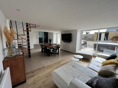 a living room with a couch and a dining room at Maison de charme avec jacuzzi - Bretagne / île de Batz in Île de Batz