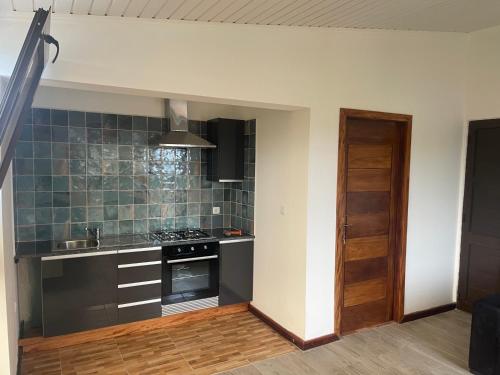 a kitchen with a sink and a stove top oven at Hotel Kenito Apartamentos T1 To T3 in São Tomé