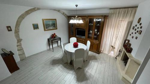 a dining room with a white table and an archway at Casa Vacanze MarGiu Pater Domus in Goriano Sicoli