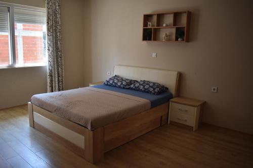 a bedroom with a bed with blue pillows on it at MANEVI Apartment in Strumica