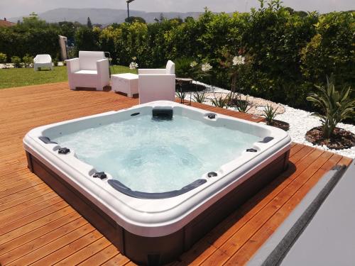 a hot tub on a deck with two chairs at Le Stelle di Orione in Fontane Bianche