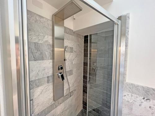 a shower with a glass door in a bathroom at Camere in Centro in Cagliari