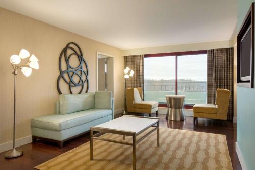 a living room with a couch and two chairs at Embassy Suites by Hilton Boston Waltham in Waltham