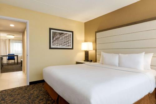 a hotel room with a large bed and a desk at Embassy Suites by Hilton Boston Waltham in Waltham