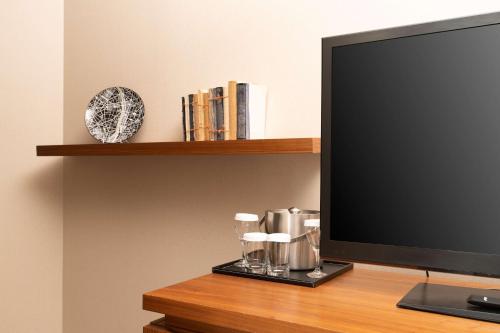 a flat screen tv sitting on a desk with a shelf at Hilton London Wembley in London