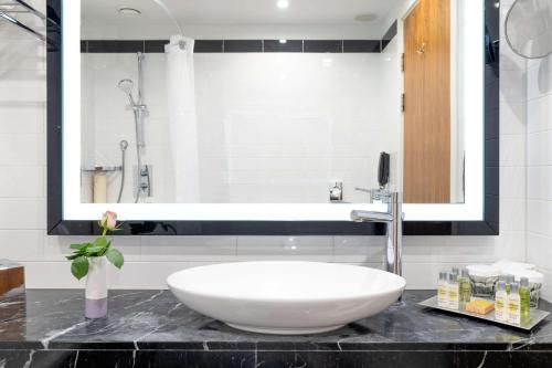 a bathroom with a large white sink on a counter at Hilton London Wembley in London