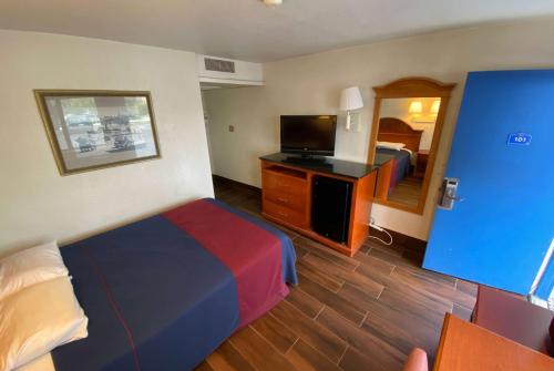 a hotel room with a bed and a television at Travelodge by Wyndham Grand Rapids North in Grand Rapids