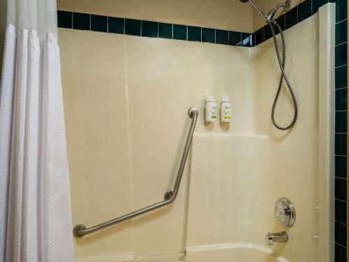 a shower in a bathroom with a shower curtain at Travelodge by Wyndham Lacombe in Lacombe