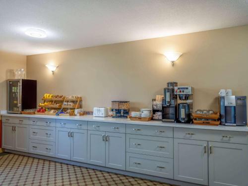 a kitchen with white cabinets and a counter with boxes at Travelodge by Wyndham Lacombe in Lacombe