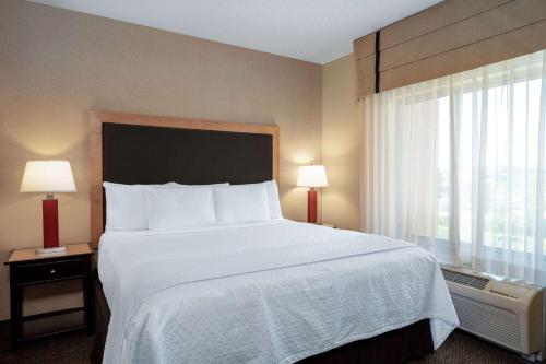 a hotel room with a large bed and a window at Wyndham Noblesville in Noblesville