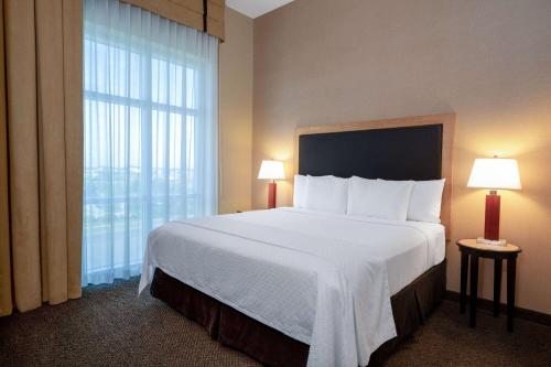 a hotel room with a large bed and a window at Wyndham Noblesville in Noblesville