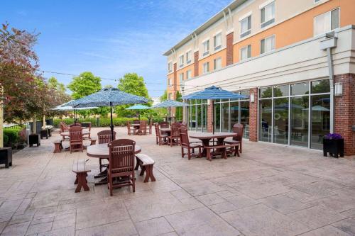 a patio with tables and chairs and blue umbrellas at Wyndham Noblesville in Noblesville