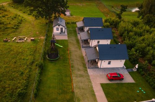 an aerial view of a house with a red car parked in front at Domki Pod Dębem in Sulęczyno