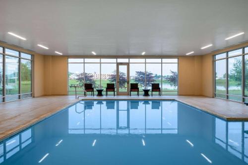 a large swimming pool with blue water in a room with windows at Wyndham Westfield in Westfield