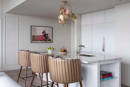 a kitchen with white cabinets and a bar with stools at Hyatt Centric Downtown Nashville in Nashville