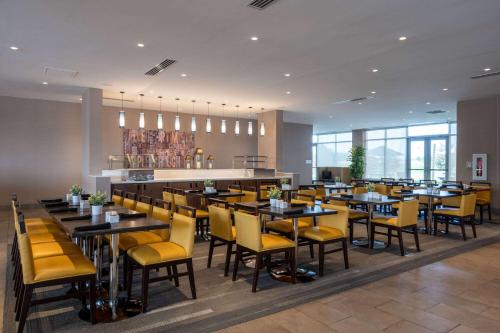 a dining room with tables and yellow chairs at Wyndham Westfield in Westfield