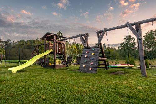 a playground with a slide and a climbing frame at Domki Pod Dębem in Sulęczyno