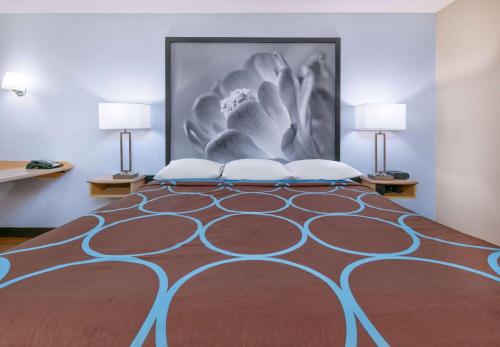 a bedroom with a large bed with two lamps at Super 8 by Wyndham New Braunfels I-35 in New Braunfels