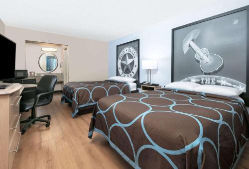 a hotel room with two beds and a desk at Super 8 by Wyndham New Braunfels I-35 in New Braunfels