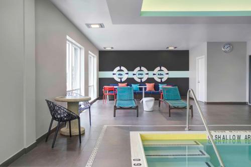 a room with a table and chairs and a pool at Tru By Hilton Toronto Airport West in Mississauga