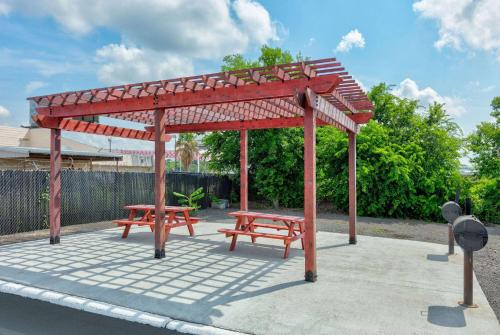 a pavilion with two picnic tables and two benches at Super 8 by Wyndham New Braunfels I-35 in New Braunfels
