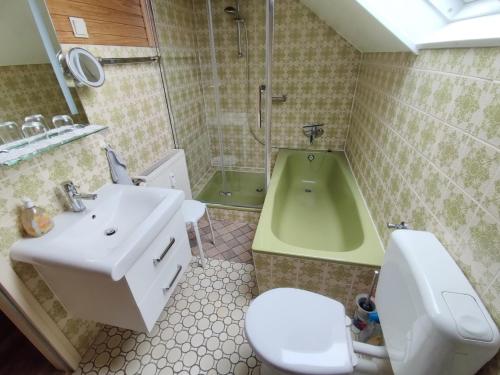 a bathroom with a sink and a toilet and a tub at Ferienwohnung Jepsen in Glücksburg