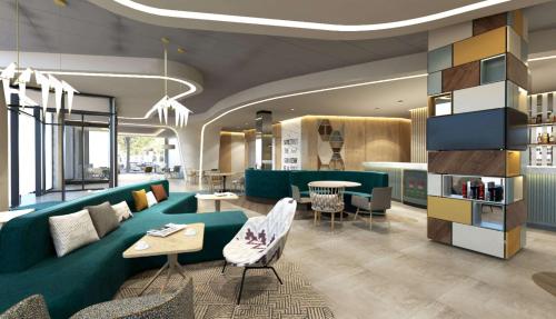 a lobby with a green couch and tables and chairs at Hampton By Hilton Szczecin East in Szczecin