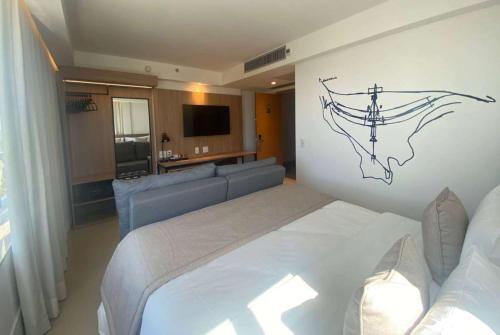 a bedroom with a large bed and a couch at Tryp by Wyndham Brasília Nações in Brasilia