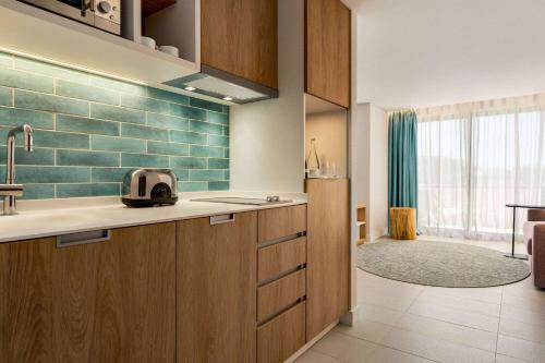 una cocina con azulejos verdes en la pared en Wyndham Residences Alvor Beach, en Alvor