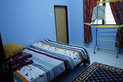a bedroom with a bed in a blue room at ZZ Homestay in Bukit Payong