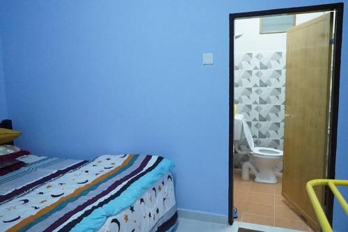 a bedroom with a bed and a bathroom with a toilet at ZZ Homestay in Bukit Payong